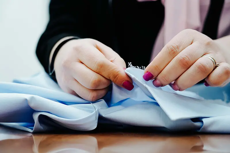 sarta fralbo intenta a cucire il colletto di una camicia