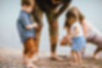 family playing with sand on the beach