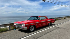 Red classic car near coastline for shoot