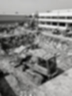 Heavy machinery performing excavation at a construction site.