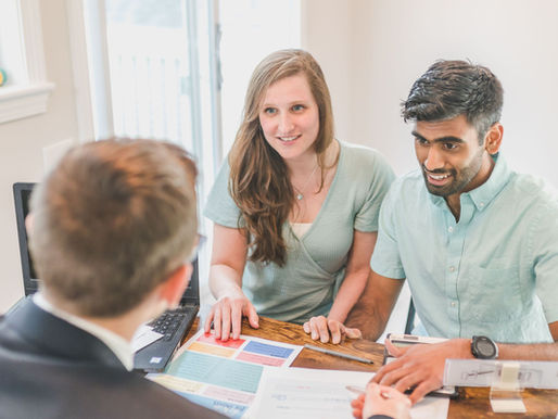 A couple in discussion with a male broker.