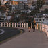 A couple walking along street of Sydney, with houses a far.