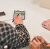 Several people gathered on a table, while a person's hand using a calculator.