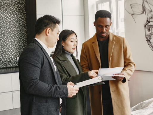 A couple discussing documents with a male broker.