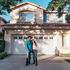 A couple standing in front of house.