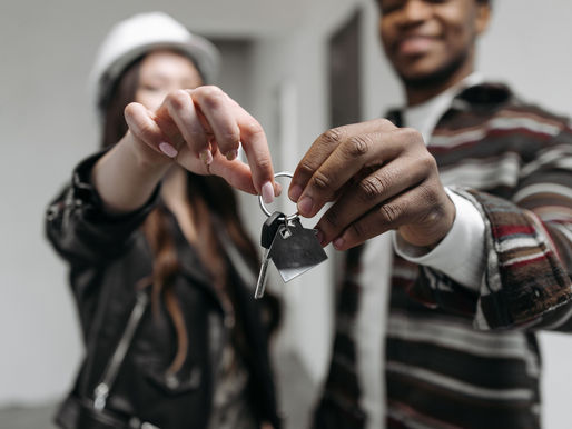 A couple holding up a house key.
