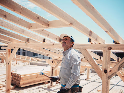 A male carpenter working within a house construction area.