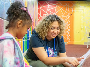 A Team Read Teen reading to a young child.