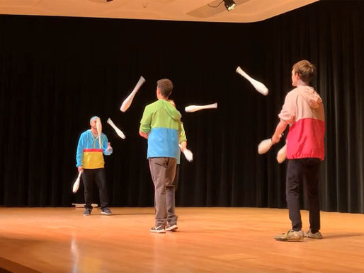 A group of people juggling on a stage.