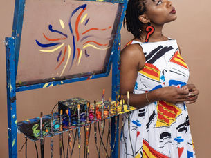 Camry Ivory standing next to her Coloratura with paintbrushes and paint in the photo.