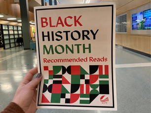 Person holding a booklet that says Black History Month Recommended Reads