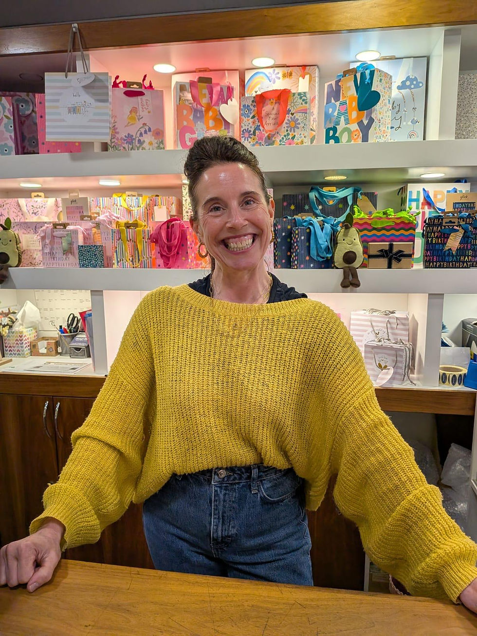 Smiling woman in yellow sweater at About Design@Six shop