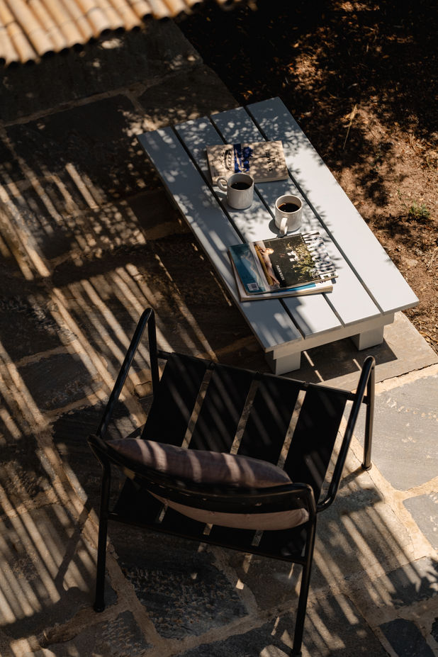 Outdoor dining terrace with wooden table and chairs at a traditional countryside stone guesthouse