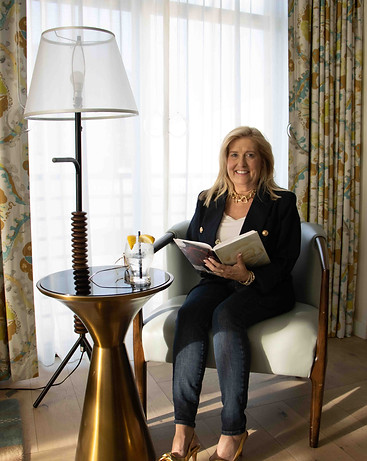 Shari Daneilak, who provides financial leadership for women founders, sits at a table with an open book and a glass of water