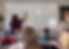 Teacher writing on the classroom whiteboard during a lesson.