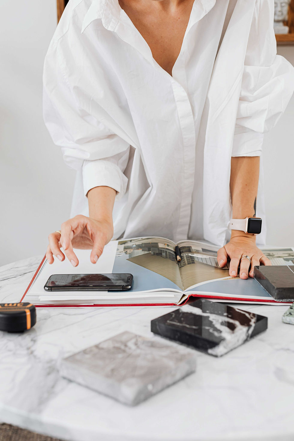 A designer reviewing a lookbook with marble and stone samples