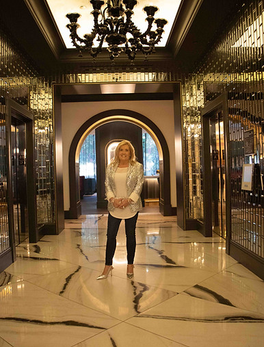 Shari Daneilak, financial strategist for female entrepreneurs, stands in a marble hallway of a luxery hotel