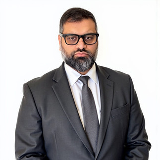 AI Headshot of Mil Patel in grey suit on white background.