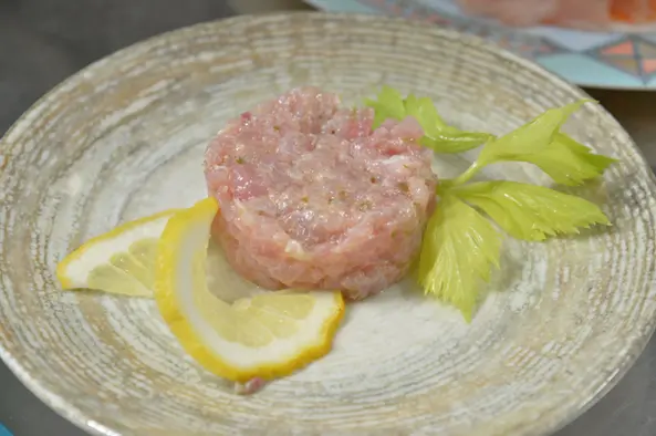 Tartare di pesce con sedano e fettine di limone