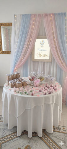 Tavolo buffet decorato per festa con dolci e tende rosa e azzurre