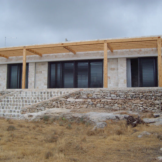 Edificio moderno in ferro e pietra con ampie vetrate.