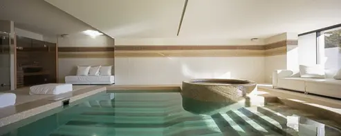 Piscina interna con idromassaggio in area wellness moderna