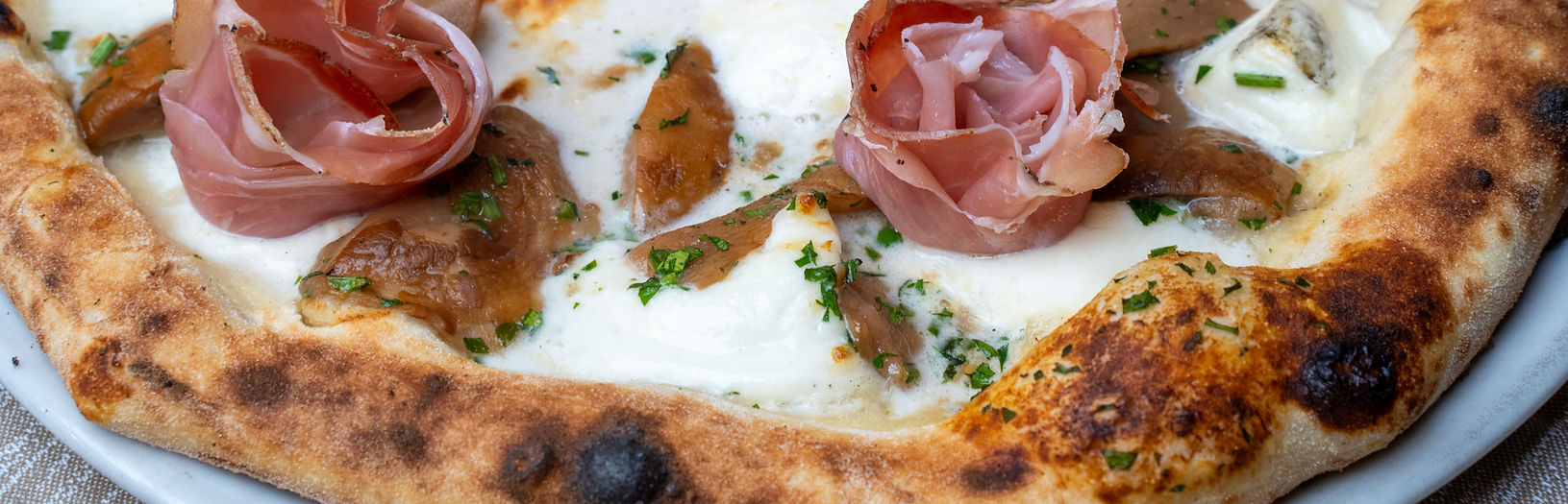 Pizza con prosciutto, ingredienti saporiti e erbe. Tradizione siciliana a Ragusa.