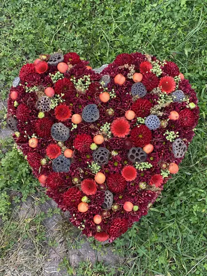 Composizione floreale a forma di cuore con fiori rossi