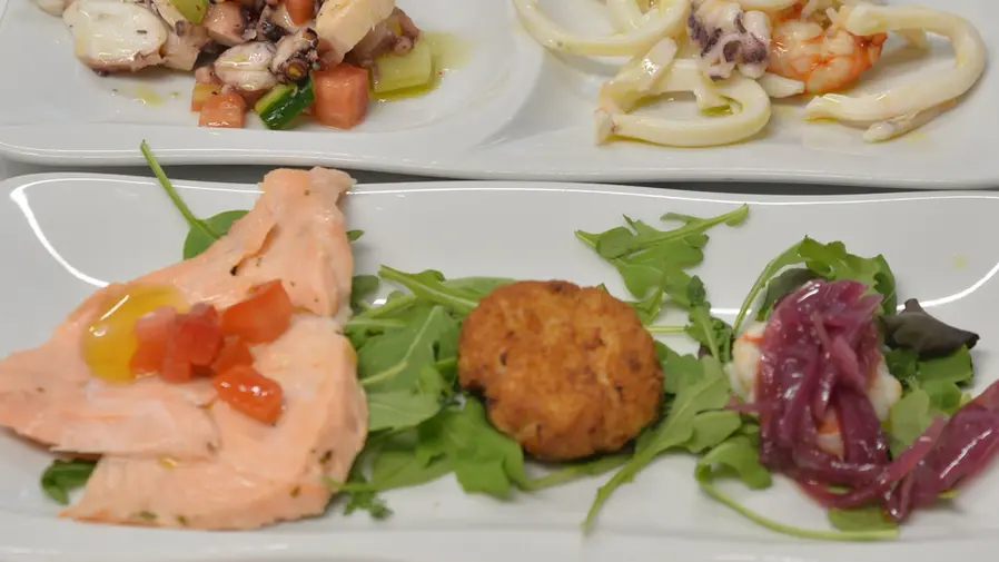 Selezione di antipasti di pesce misti su piatti bianchi