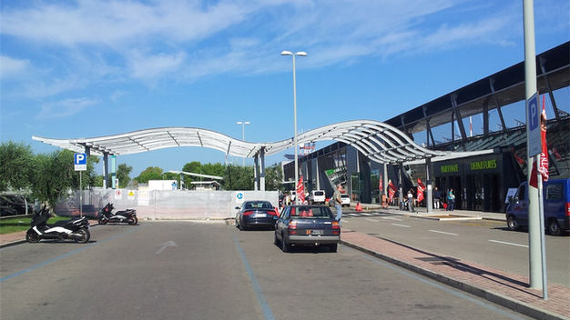 Esterno edificio moderno con tettoie curve e veicoli