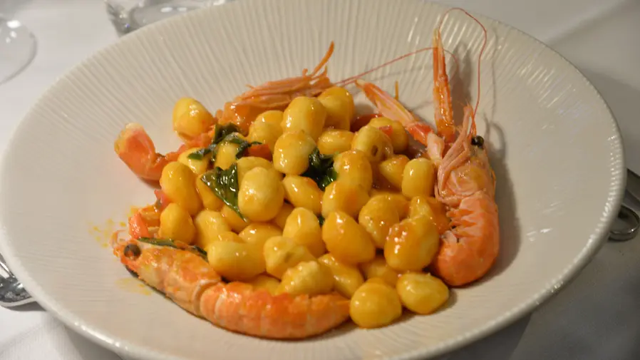 Piatto di gnocchi con gamberi freschi e prezzemolo