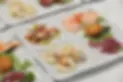 Selezione di antipasti di pesce freschi su piatti bianchi