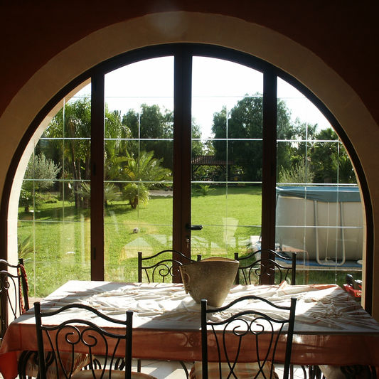 Infisso in alluminio ad arco con vista sul giardino