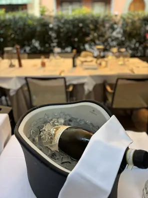 Bottiglia di vino nel secchiello del ghiaccio al tavolo.
