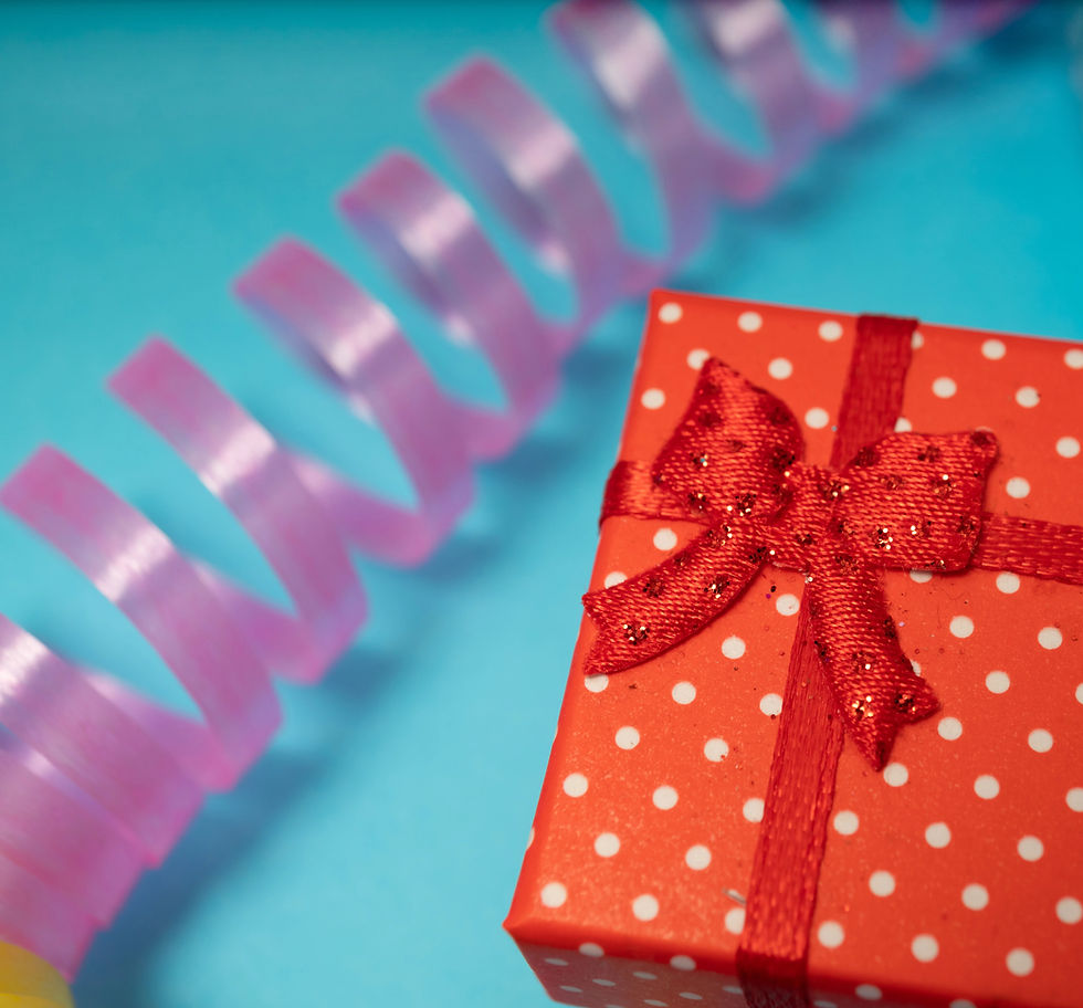 Regalo rosso a pois con nastro e stelle filanti viola