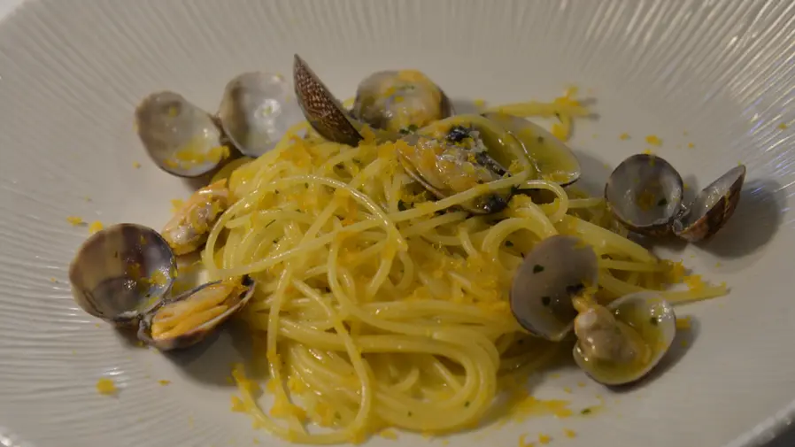 Spaghetti alle vongole serviti in un piatto bianco.