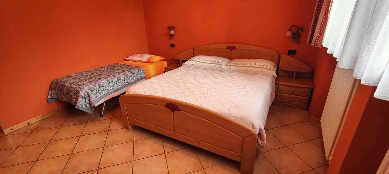Camera con letto matrimoniale in legno e letto singolo