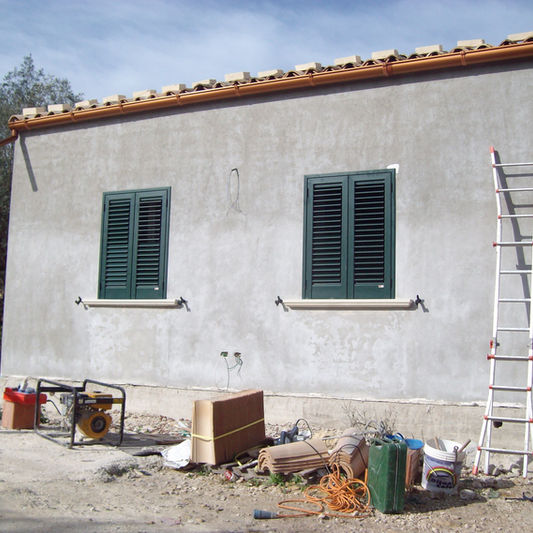 Infissi in alluminio verdi su facciata in costruzione.