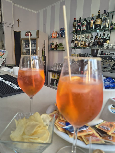 Due calici di spritz con patatine sul bancone del bar