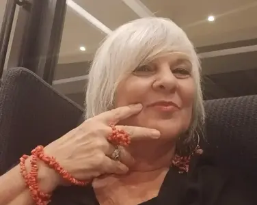Donna sorridente che esprime accettazione di sé, consapevolezza e benessere a ogni età