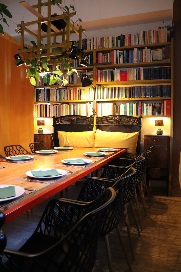 Tavolo apparecchiato per aperitivi in una sala con libreria.