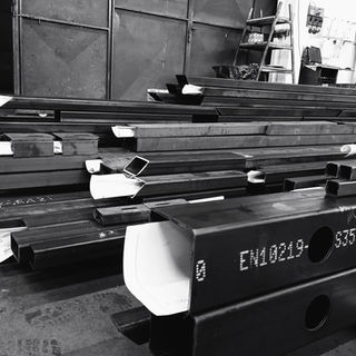 Travi in acciaio impilate in un magazzino industriale