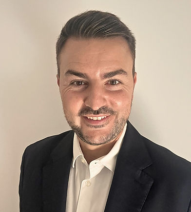 Primo piano di un uomo sorridente in giacca e camicia bianca