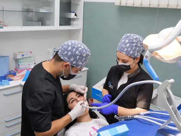 Dentista Catania esegue trattamento su paziente in studio.