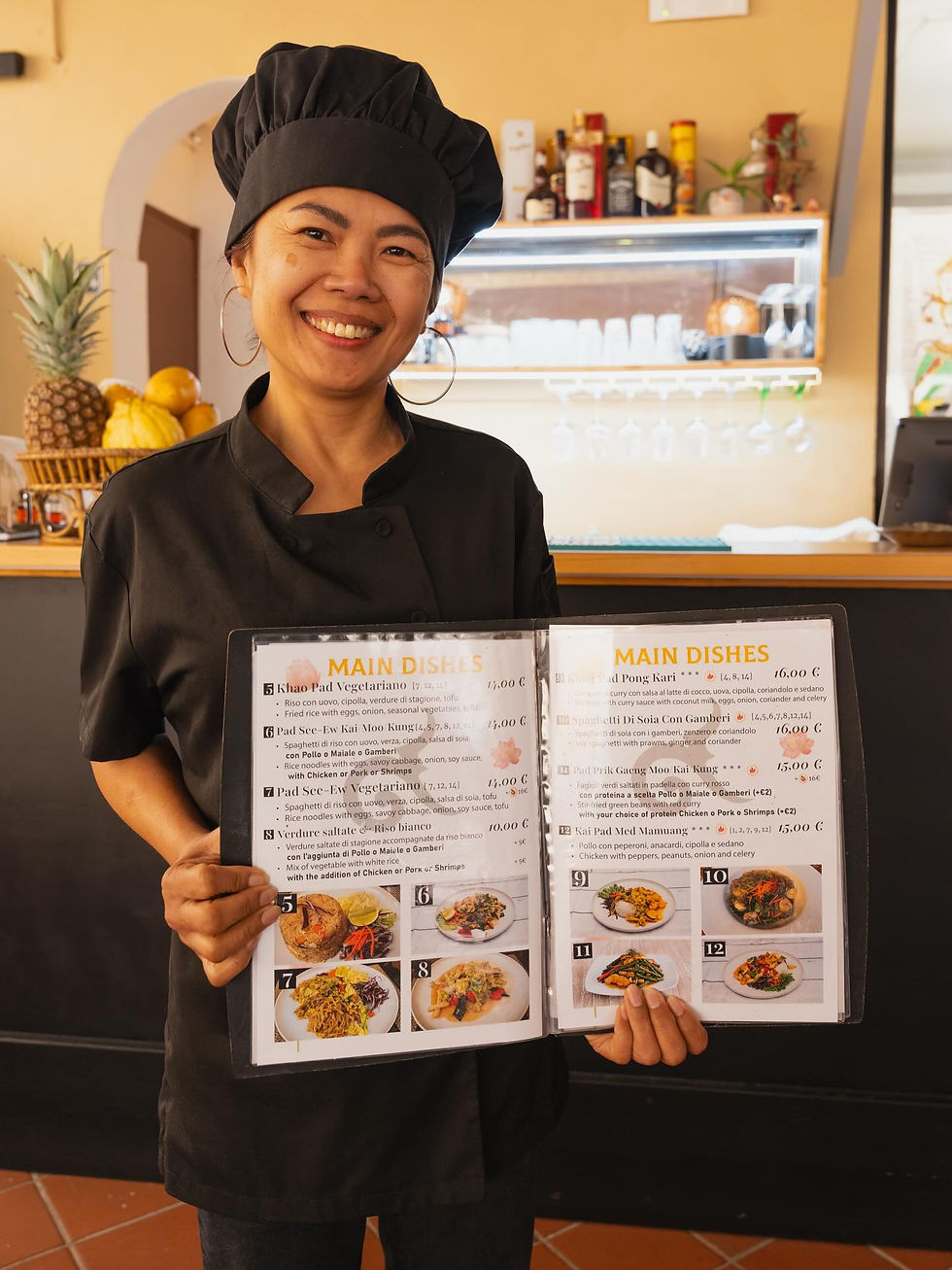 Chef sorridente del ristorante thailandese a Pisa con il menu
