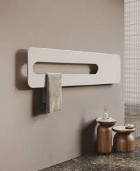 Termoarredo di design bianco con asciugamano in bagno