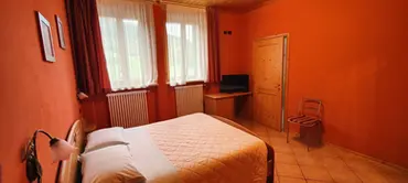 Camera da letto con pareti arancioni e letto matrimoniale