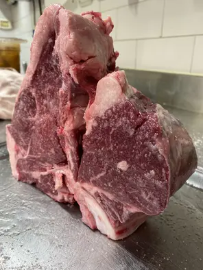 Taglio di bistecca alla fiorentina cruda sul bancone