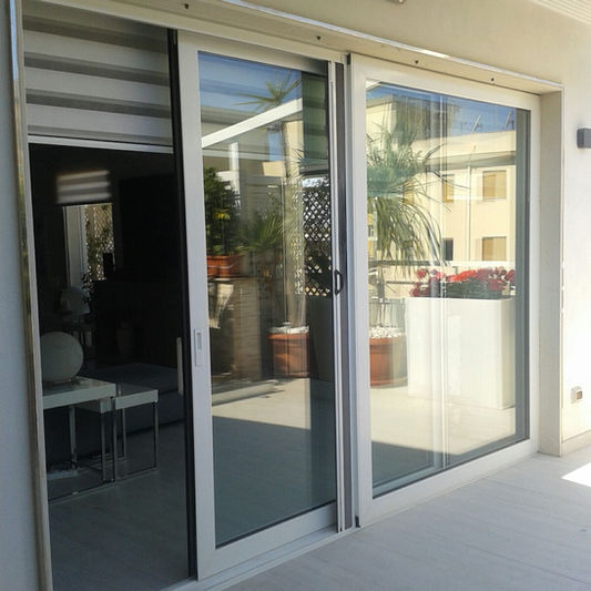 Porta scorrevole in alluminio con ampie vetrate per esterni
