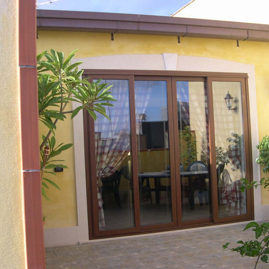 Porta finestra in alluminio effetto legno su un patio.